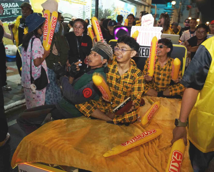 Pawai Extrajoss Ultimate Takeover Bandung menghadirkan anak-anak muda yang diarak di atas kasur menyusuri Jalan Braga sebagai simbol semangat mengangkat mimpi anak muda di 2026 (Dokumentasi: Extrajoss)